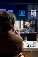 Cybersecurity expert helped by coworker during videocall to look for company security vulnerabilities and injected malware. Programmer and colleague in teleconference installing fortified code on PC photo