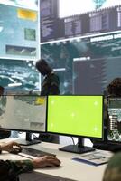 Trooper following CCTV satellite surveillance on pc next to isolated mockup screen, tracking deployed units with GPS location. Army conscript operating in command post headquarters. photo