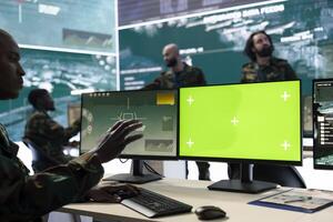 Army personnel uses isolated copy space and radar footage in general headquarters, working on a defense program mission. Recruit monitoring real time data with satellite CCTV imagery. photo