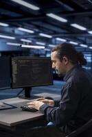 Admin typing on desktop PC in server farm establishment, ensuring data remains shielded from potential threats. IT specialist coding at computer desk, safeguarding data center against malicious access photo