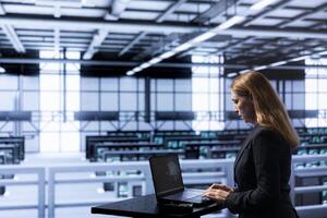 Admin in data center using laptop to visualize artificial intelligence neural networks made up of interconnected nodes. Supervisor oversees AI systems processing information photo