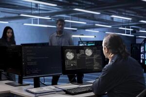 Admin working in data center accommodating traffic for people from worldwide locations. Employee at computer desk in server hub hosting websites and delivering web content to clients over the internet photo
