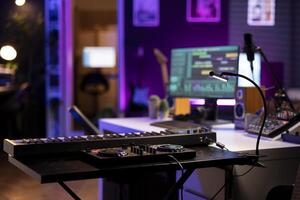 Empty home studio used to produce music and tunes with electronic devices, acoustics instruments and soundboard with control panel. Space equipped with amplifier and mixing tools. photo