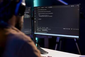 Programmer writing code on computer to futureproof company network from downtimes and unexpected system failures. Man deploying programming script increasing data security photo
