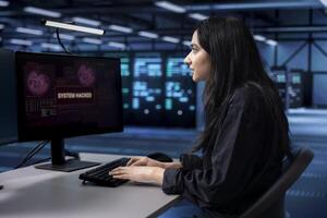 Technician in server farm facility frightened by hacker passing company firewall and stealing data. Afraid woman panicking after seeing security breach notification on PC monitor in data center photo