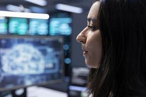 System administrator using AI tech to do checkup in server room providing storage, close up. Indian woman in data center using PC to enable artificial intelligence to process datasets for training photo