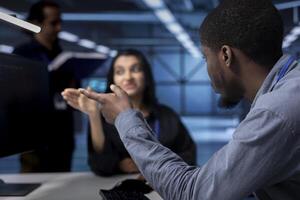 Supervisor arguing with engineer worker after seeing error in server room equipment. Close up shot of annoyed manager berating employee in data center after noticing malfunction photo