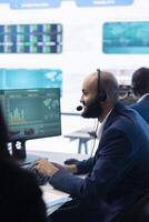 Company associate examining infographics in a organizational headquarters, telecommunications operator analyzing annual reports and statistics. Resources allocation activity in office. photo