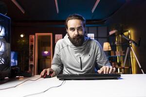 Man using gaming mouse and keyboard to play entertaining videogame, moving character. Pro gamer using professional computer peripherals to enjoy relaxing game at home, having fun photo
