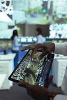 African american manager overseeing delivery truck drivers activity, uses a tablet to monitor traffic on satellite navigation. Operator sends gps coordinates to couriers, delivery service. Close up. photo