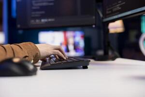 Man working cybersecurity job from home using computer to fix security loopholes. IT remote worker at desk typing on keyboard, installing safeguard code on PC to prevent cyberattacks, close up photo