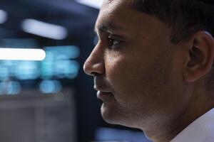 Technician in high tech facility walking through server rigs used for computationally intensive tasks such as molecular modeling or physical simulations, doing equipment maintenance, close up photo