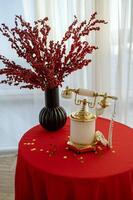 There is a vintage white telephone on the table. The table is covered with a white tablecloth. photo