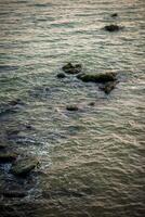 Rocks jut out into the sea, and the structure of the water is visible. photo