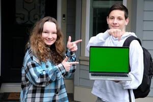 Cropped image of a female college student using her laptop computer and doing a school project with her friends at park. laptop white screen mockup photo