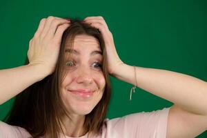 Close-up portrait of surprised beautiful girl holding her head in amazement and open-mouthed. Over white background. photo