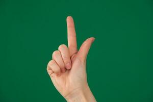 pointing at something with your index finger. isolated green background photo