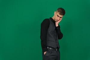 Photo of attractive dreamy guy dressed green pullover arm fist cheek looking empty space isolated yellow color background