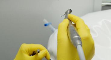 Surgical instruments in the operating room. A nurse in a surgical suit and gloves is preparing for a tooth implant operation. Dental probe, tweezers, scalpel, needle holder, rasps on instrument table. photo