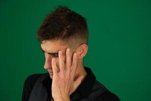 Handsome man with blue eyes and beard wearing denim jacket peeking in shock covering face and eyes with hand, looking through fingers with embarrassed expression. photo