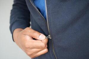 Man zipper on a jacket in cold autumn day. photo