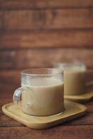 Enjoy a warm cup of coffee served in glass mugs on a rustic wooden background photo