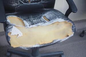 A WornOut Office Chair that has Exposed Foam and is in poor condition photo
