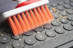 Cleaning Your Keyboard with a Brush An Effective Method for Dust Removal photo