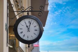 A Beautiful Classic Wall Clock Set Against a Serene Blue Sky Background photo