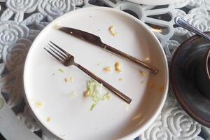 An empty plate with a spoon rests after a delicious, satisfying meal has been enjoyed photo
