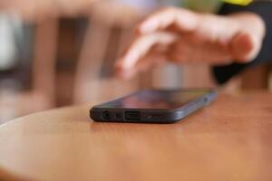 man hand picking up smart phone mobile to receive a call photo