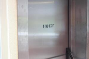 Fire Exit Signage prominently displayed in an Urban Environment alongside a Yellow Taxi cab photo