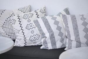 Stylish throw pillows with geometric patterns adorning the sofa beautifully photo
