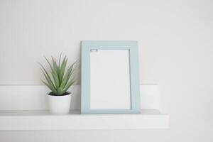 A minimalistic frame with a vibrant plant elegantly placed on a shelf photo