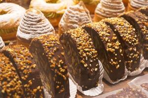 An array of pastries and eclairs are presented in the bakery display case with allure photo