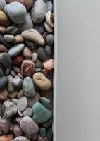 Cardboard Partition Separates Clean White Surface And Scattered Sea Stones Stock Photo For Vertical Story