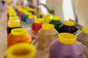 Textile factory, multi-colored spools of colored threads in production, weaving machine photo