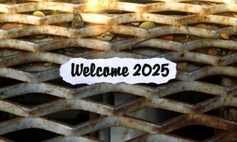 Welcome 2025 note on torn paper with sunlight. New year concept with typographic 2025. Motivational words to welcome the new year 2025 photo