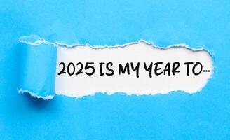 2025 is my year to, word on white background and torn blue paper. New year concept with typographic 2025 on paper. Motivational words for the new year 2025 photo