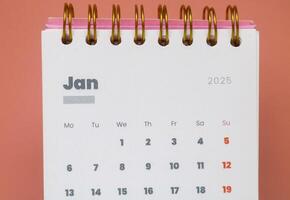 Close up of January month of the beginning of the year 2025 in the 2025 calendar in pink isolated on a pink background. Calendar and Note Pad Happy New year 2025. Z photo