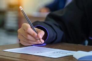 Asian students are taking exams to measure learning in the classroom. Soft and selective focus. photo