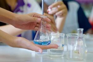 Close-up of a student performing an acid-base titration experiment. Concept of chemistry lab, science, experiment, skills, learning. photo