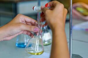 Close-up of a student performing an acid-base titration experiment. Concept of chemistry lab, science, experiment, skills, learning. photo