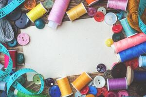 Colored threads centimeter and buttons, pair of scissors on the table. Copy space photo