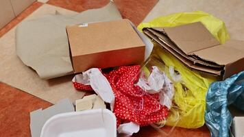 Various household trash materials on tiled floor displayed for recycling photo