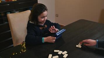 Young girl enjoying a tabletop game with family in a cozy setting photo