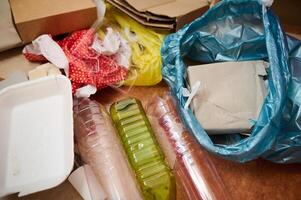 Assorted waste materials including plastics, cardboard, and packaging displayed on a surface photo