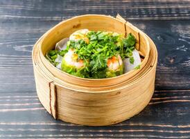 coriander siomai served in bamboo steamer isolated on wooden table side view of hong kong food photo