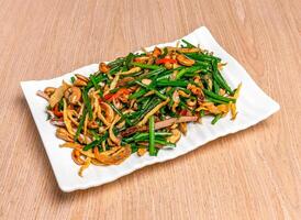 Stir Fried Garlic Chives with Cashews and starz cook served in tray dish isolated on wooden table side view of hong kong food photo