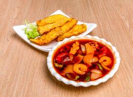 Braised Wontons with seafood soup served in tray dish isolated on wooden table side view of hong kong food photo